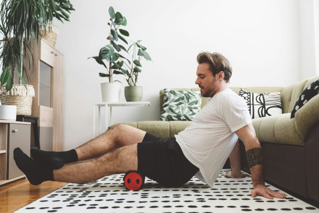 Caucasian athlete massaging his muscles with foam roller